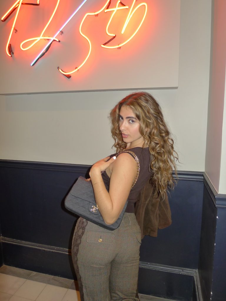 Long curly hair with warm dimensional color, styled over the shoulder